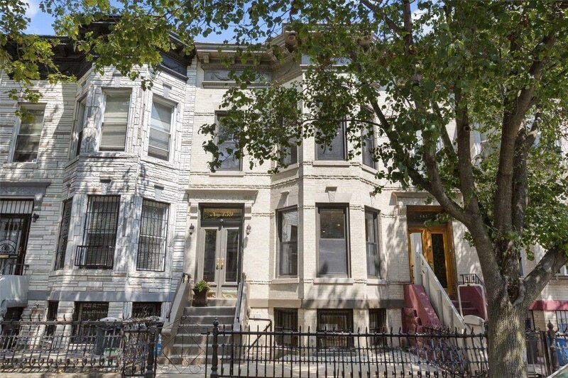 Beautiful townhouse in Brooklyn with a classic facade, gated entrance, and lush greenery