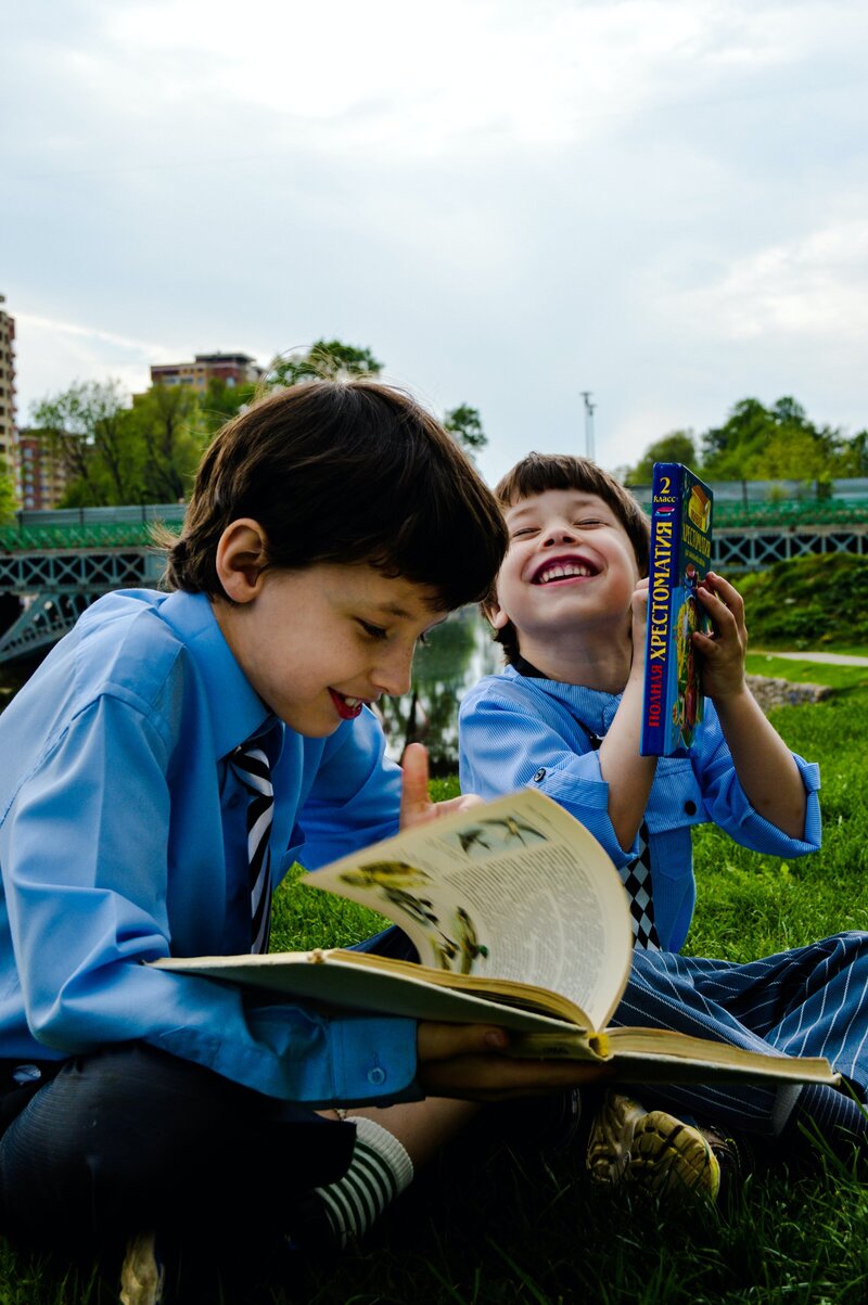 Two students sitting outside reading