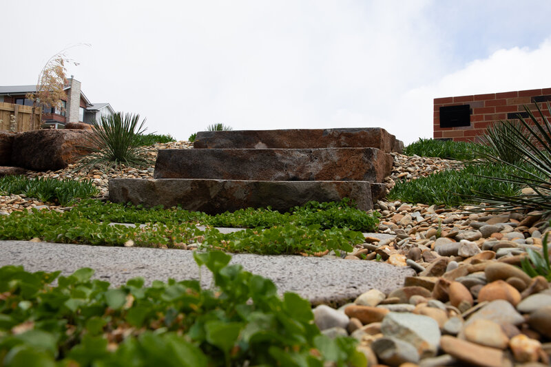 Rock work steps surrounded by greenery and paving by total landscapes & design