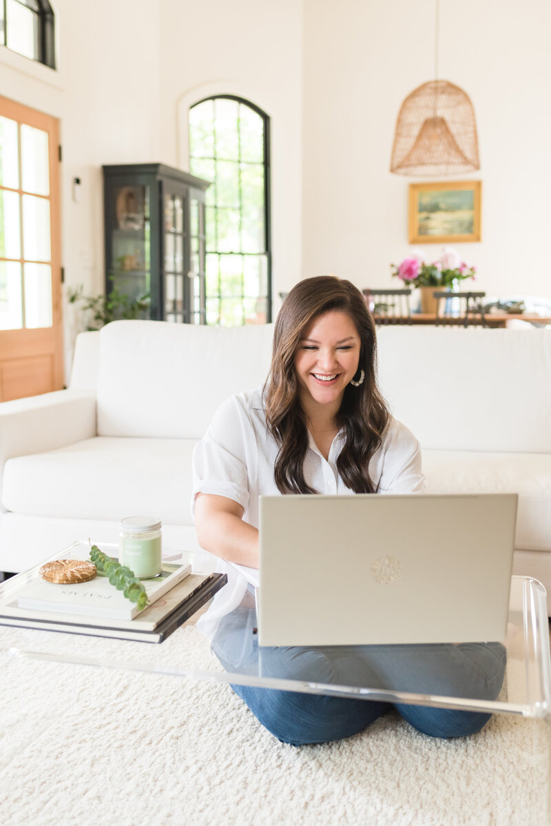 Madison Dearly smiling while working on her laptop