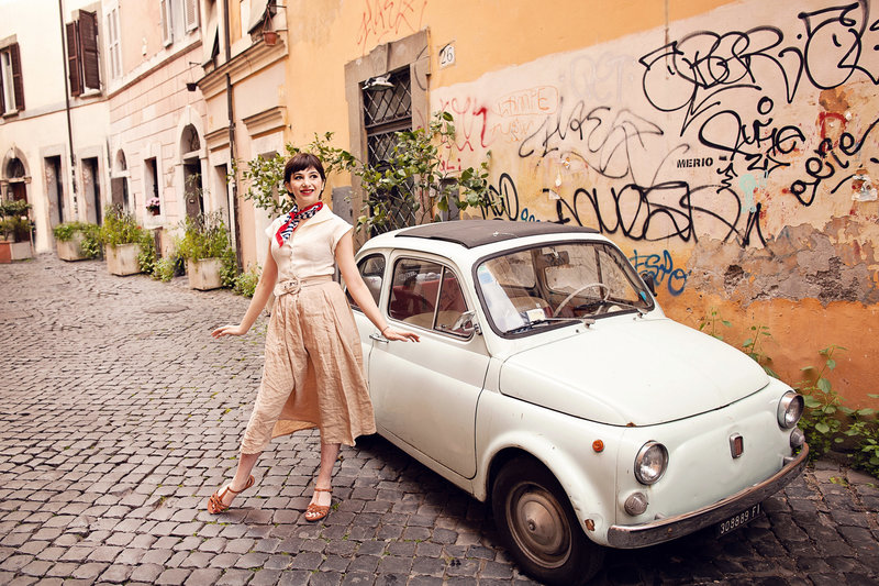 An Audrey Hepburn styled shoot in front of an old white fiat. Taken by Rome Solo Travel Photographer, Tricia Anne Photography