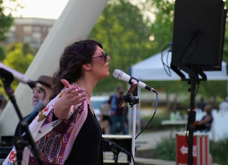 A person with their arms outstretched singing