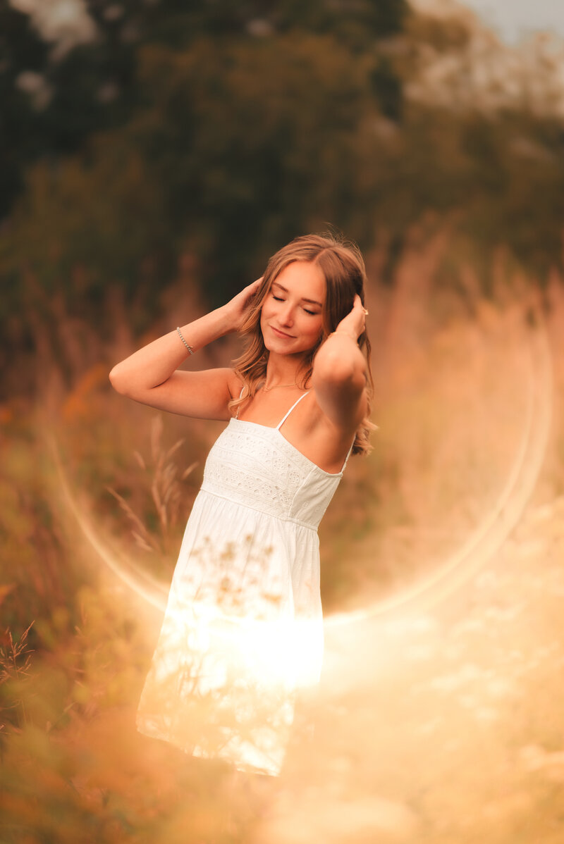 Senior girl walking through a flower garden path during a natural light senior photography session in the Twin Cities.