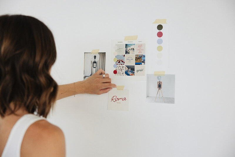 a woman with her brand materials on the wall during a branding session