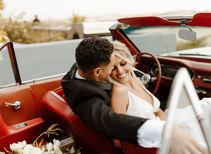 bride and groom in vintage car at wedding in California