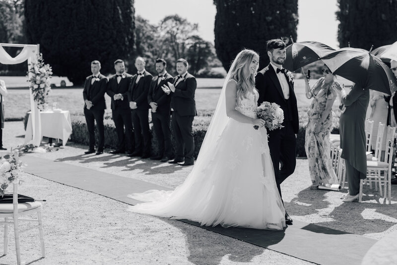 bride-and-groom-walk-back-down-aisle-castlemartyr-gardens