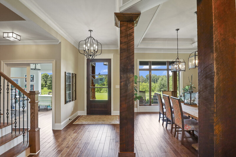 entryway with large wooden pillars and hard wood floors