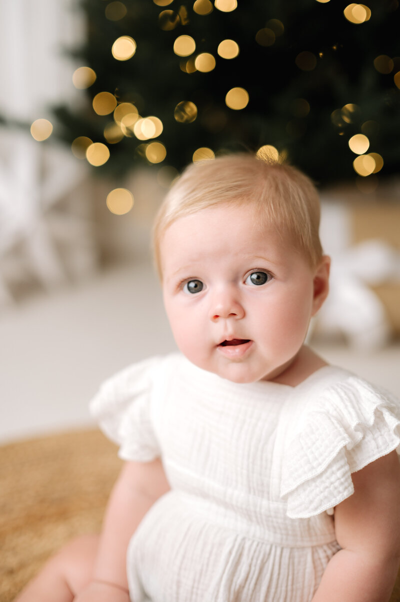 Little girl smiling on a rocking horse at a christmas photoshoot in Billingshurst