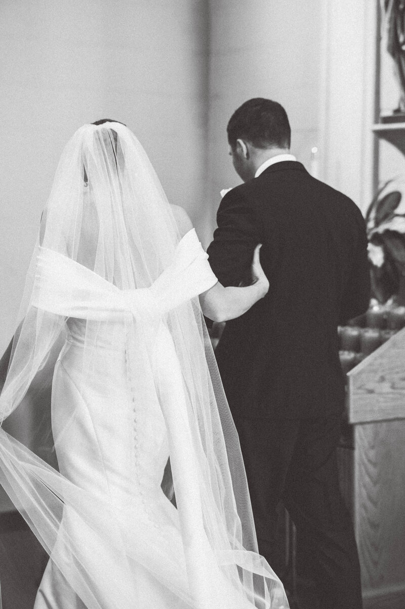 bride and groom walking arm in arm during the catholic ceremony