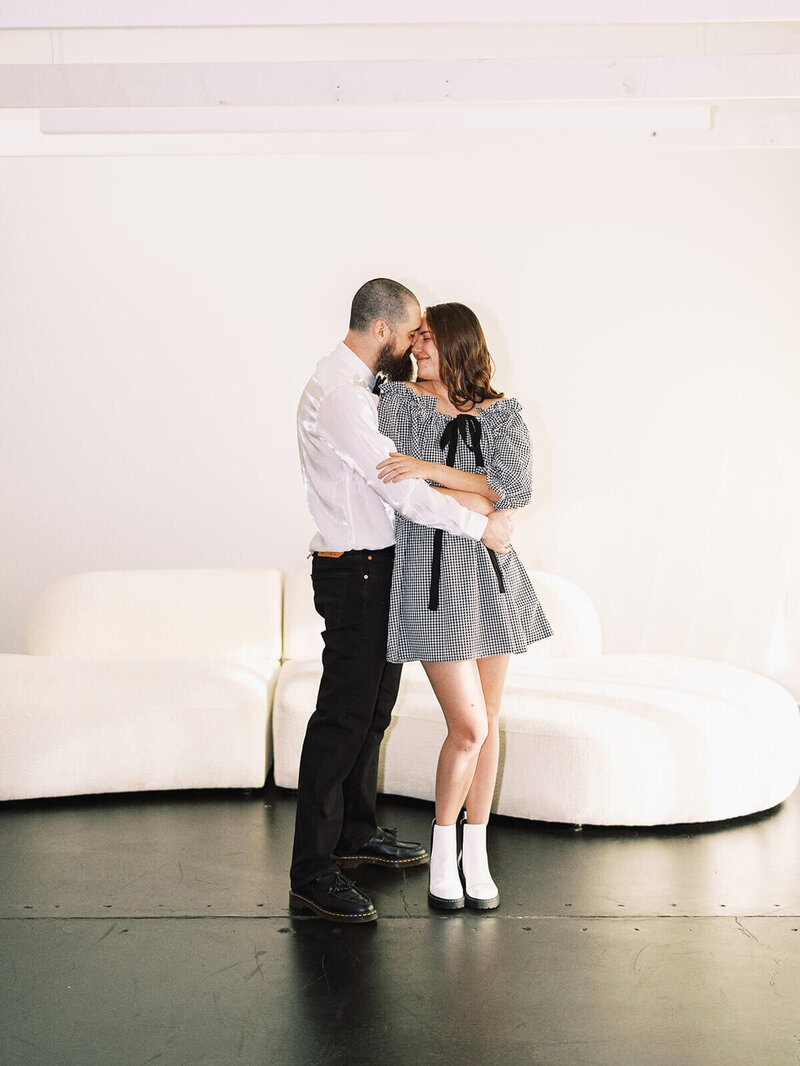 A couple dressed in black and white embrace, representing a styled photoshoot planned by Heather. 