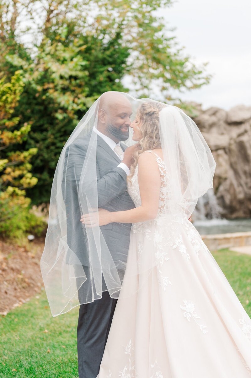 A bride and groom kiss under her veil 