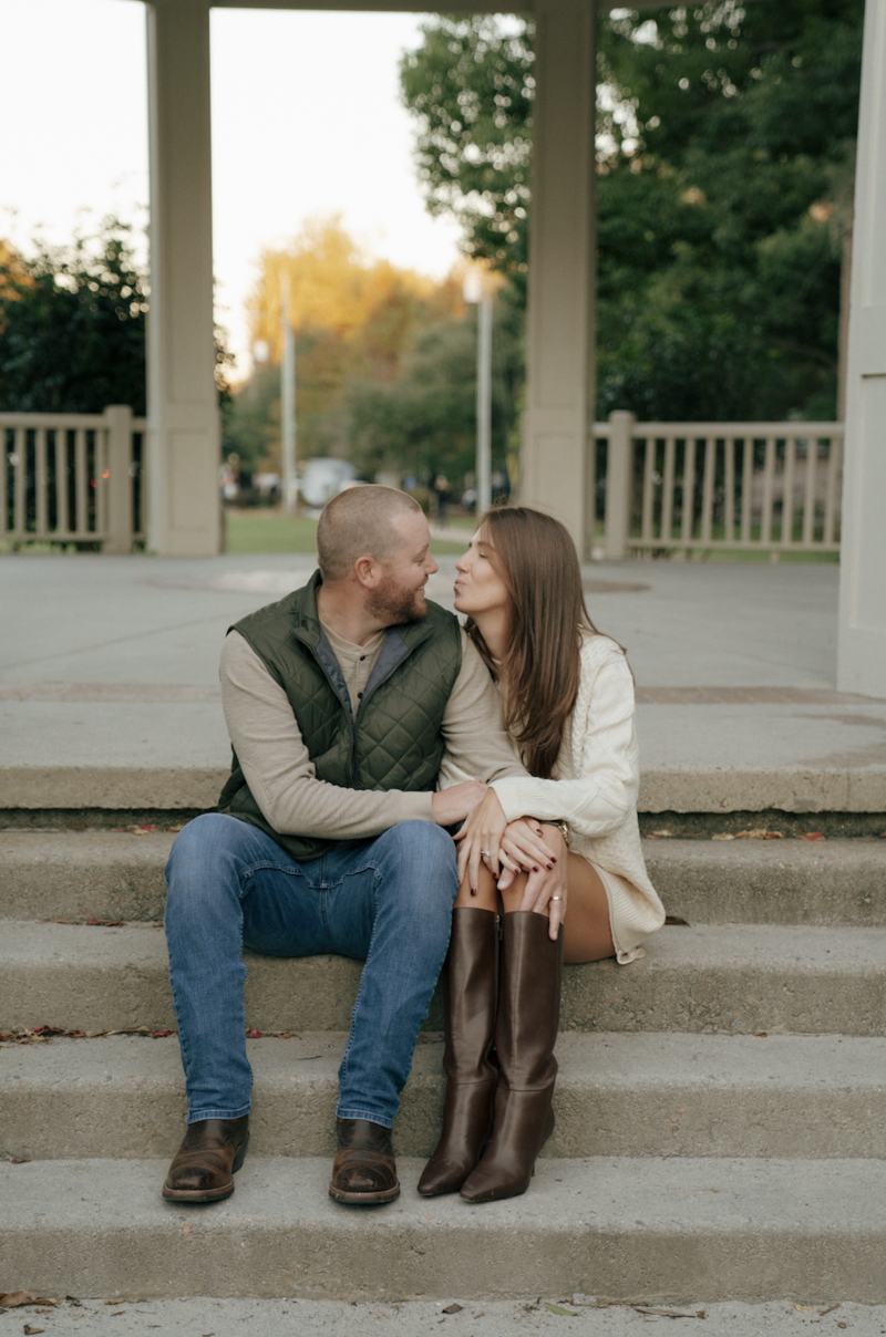 Couple standing on a gazebo at Hampton Park in Charleston, sharing a quiet moment at sunset with warm golden light.