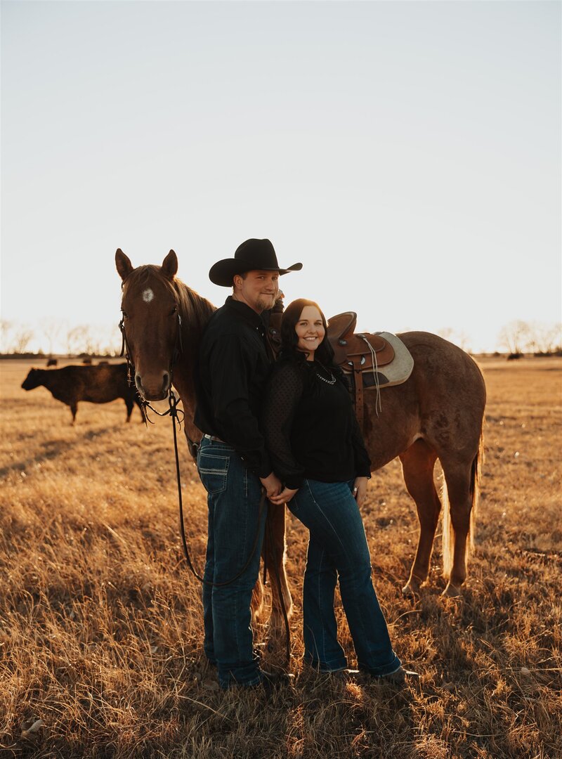 Couple posing in Nebraska's scenic outdoors, with the man wearing a western hat, capturing a rustic and romantic vibe against the beautiful natural landscape.