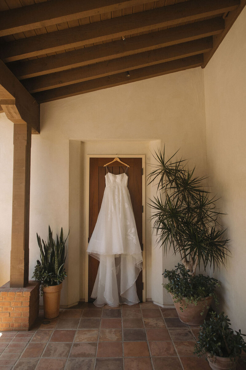Wedding dress hanging on bridal suite door at The Inn at the Mission San Juan Capistrano