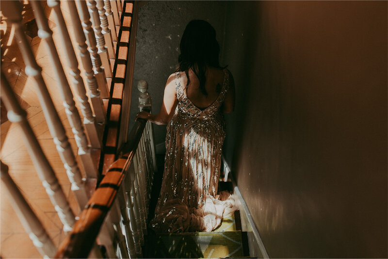 Bride with glittery dress walking down stairs
