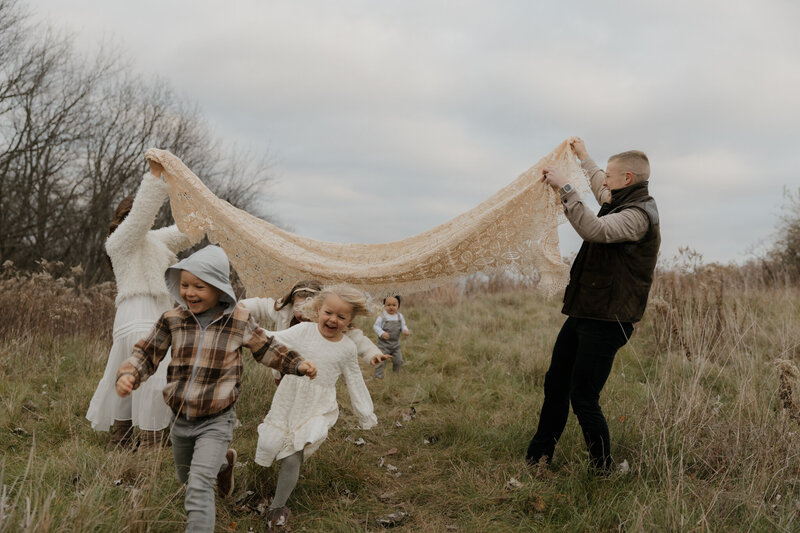 family running under blanket