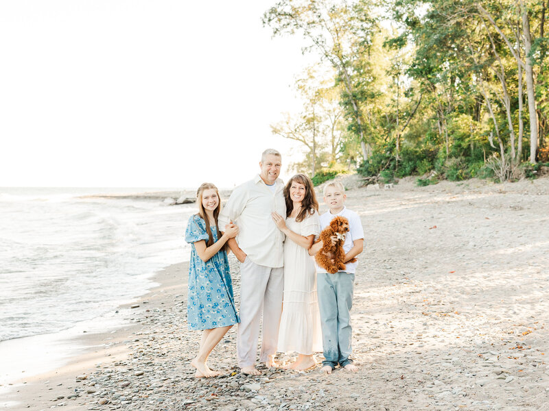 Family standing together and smiling for Lake Erie family portraits.