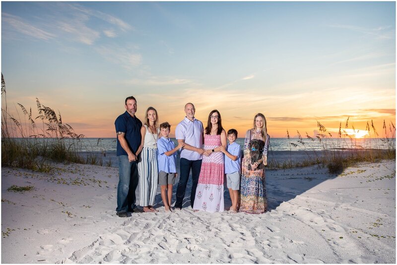 Group photo of a family enjoying a late afternoon on the beach during sunset.