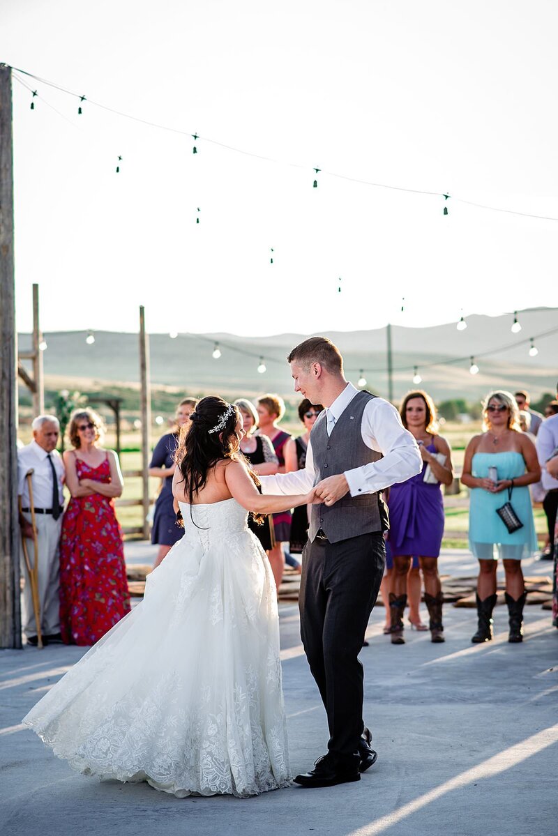 Bride and groom dancing together for their first dance on the outdoor dance floor in Montana