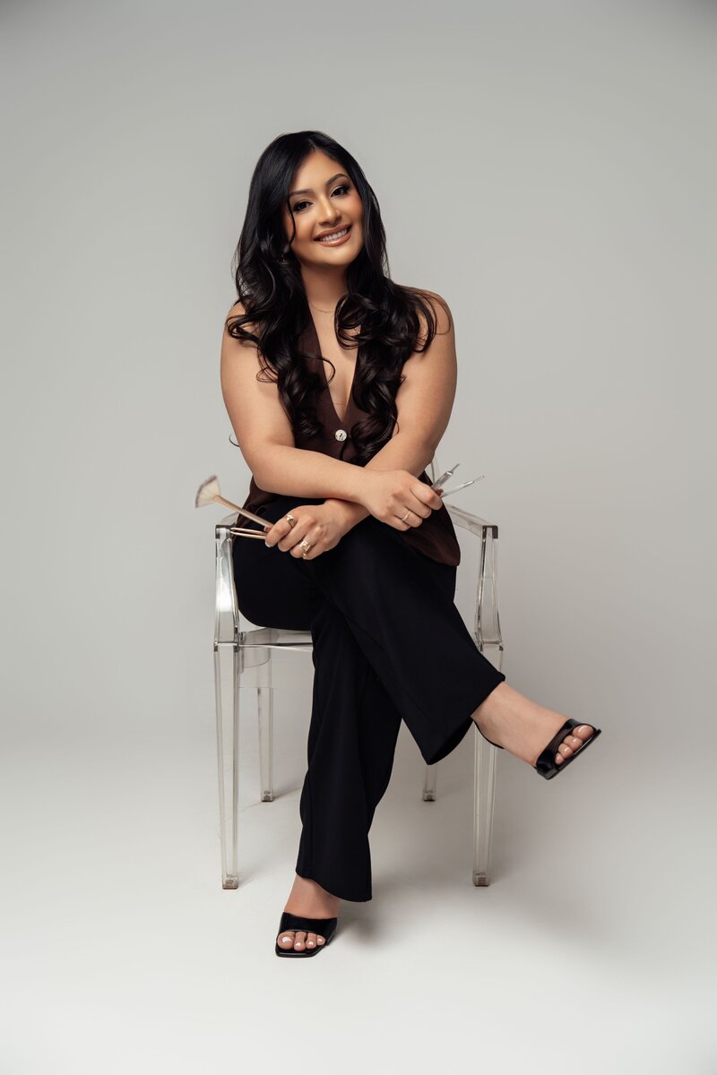 Bianca sitting on chair smiling at camera with fan brush