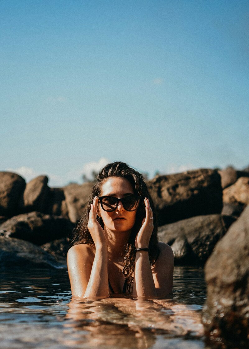 woman in the water surrounded by rocks