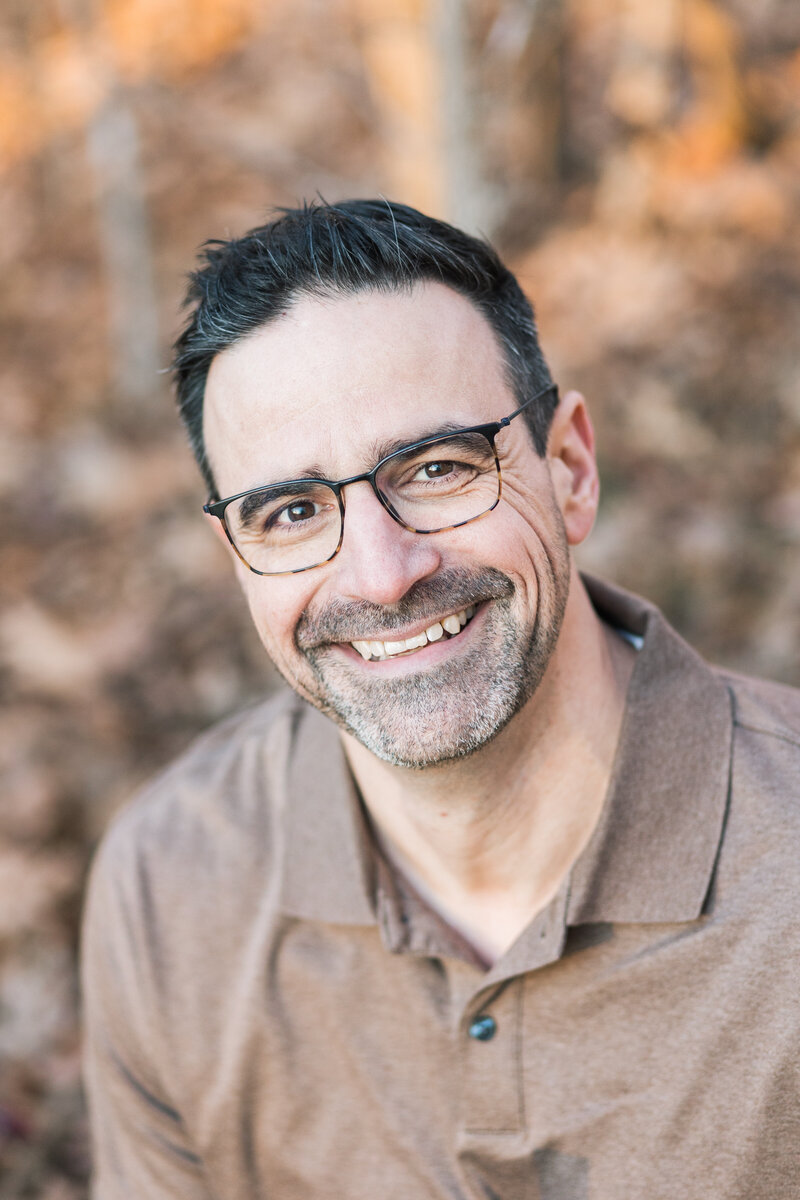 Headshot of Brian Sellers, a destinationwedding videographer based in Williamsburg, VA, sitting and smiling at the camera