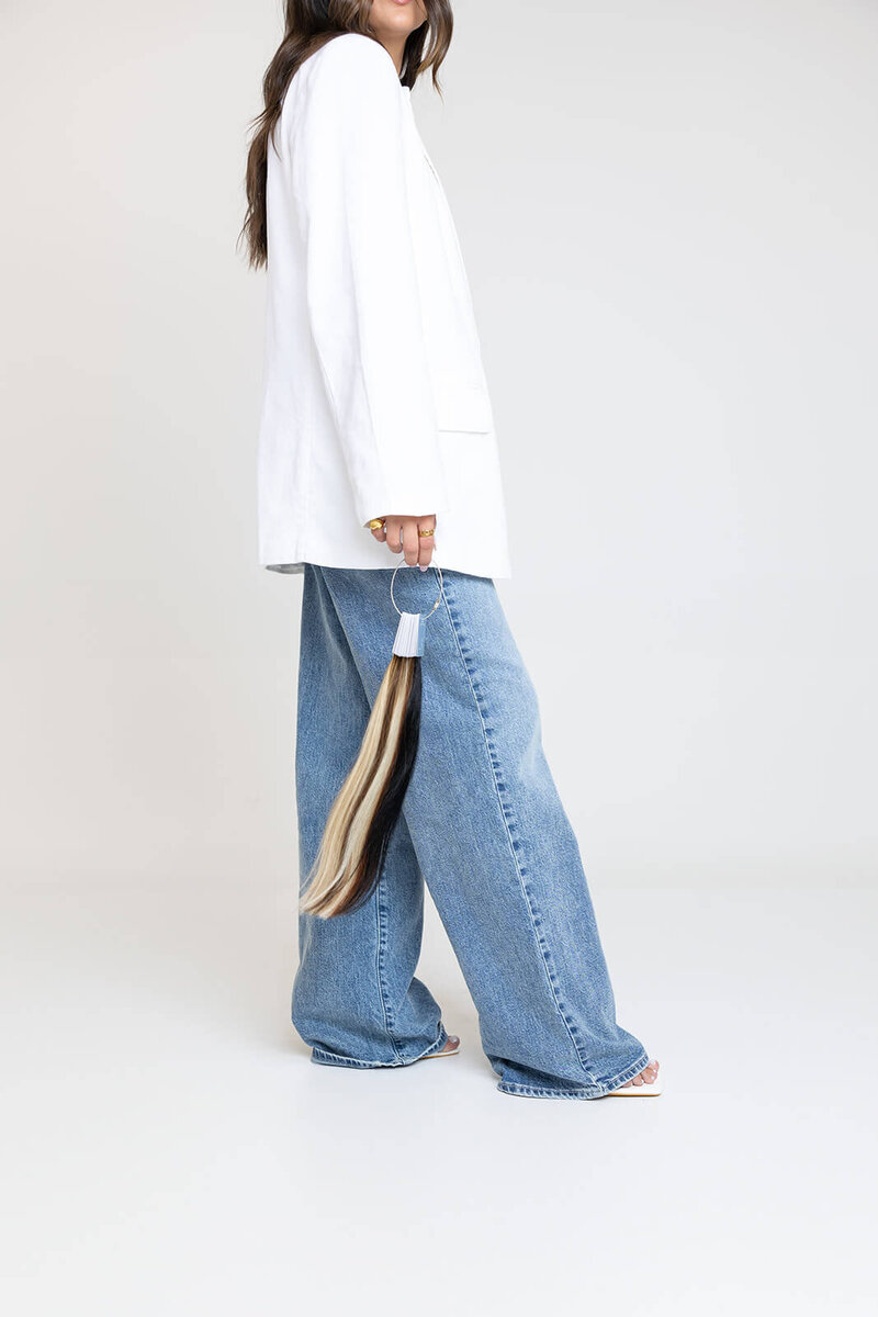long-island-hair-stylist-in-white-jacket-and-blue-jeans-holding-hair-extensions-BFC-9