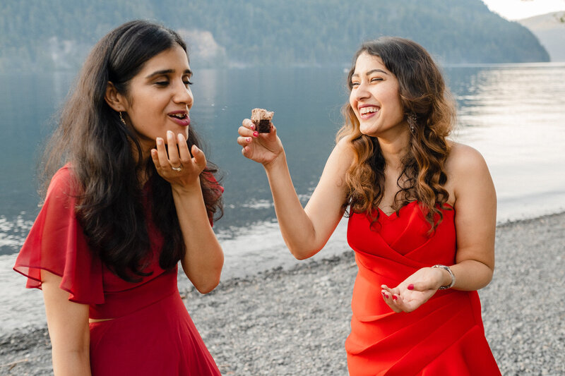 Bride feeds cake to her maid of honor.