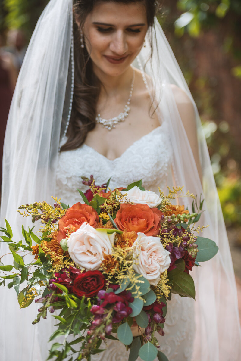 Bride looking at bouquet  from Allburn's Florist.