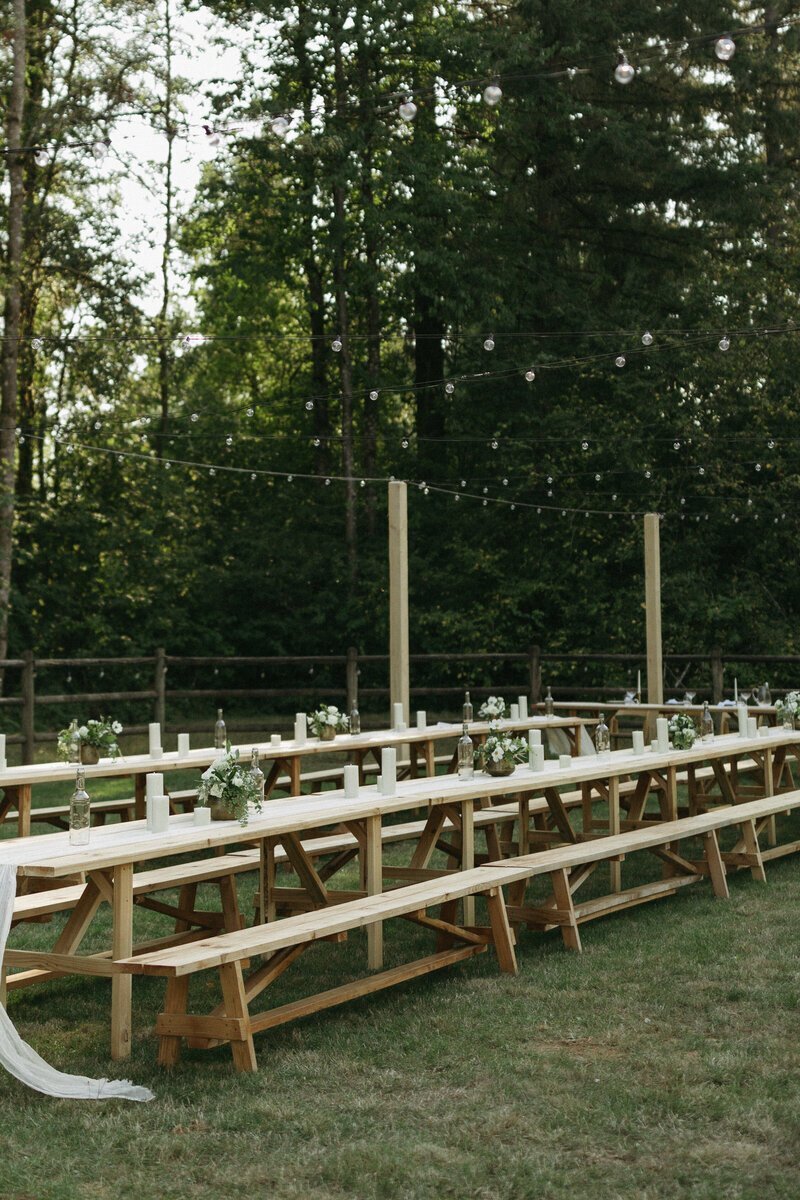 Outdoor wedding reception with wooden tables and white floral centerpieces by destination wedding photographers Erica Rochelle Photography