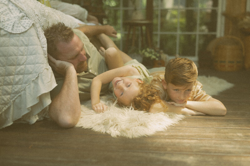 A father plays on the floor of Das Hinter Haus Studio in Atlanta, GA with his two young children. 