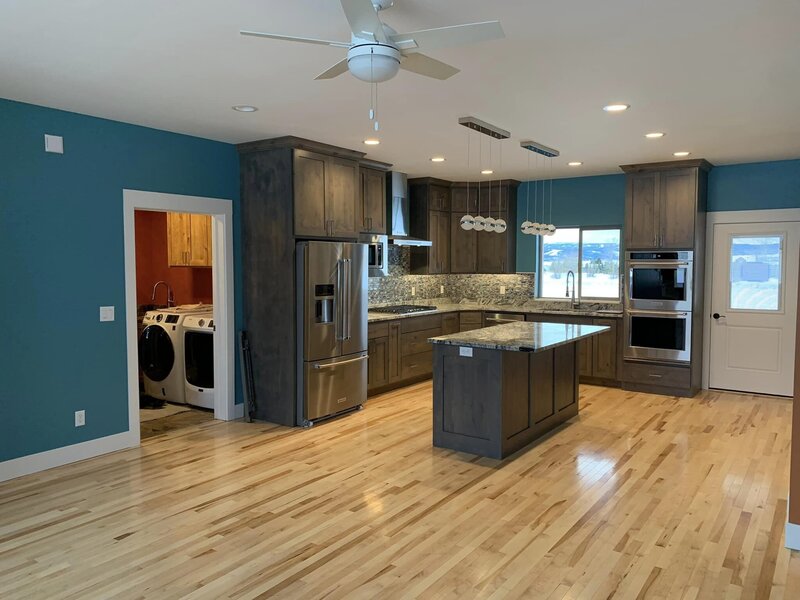 Kitchen with bright blue walls, custom wood cabinets and island counter top
