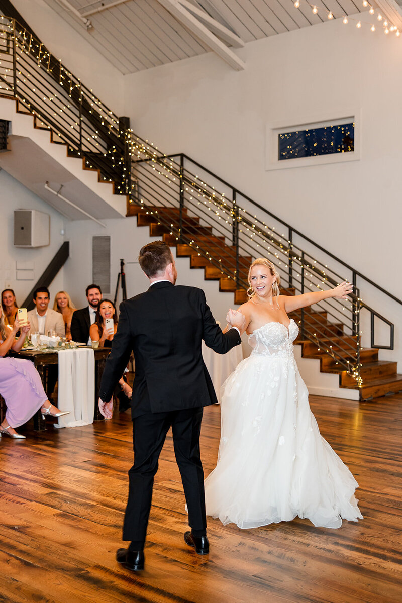 Wedding couple doing their traditional dance in the hall with grand staircase