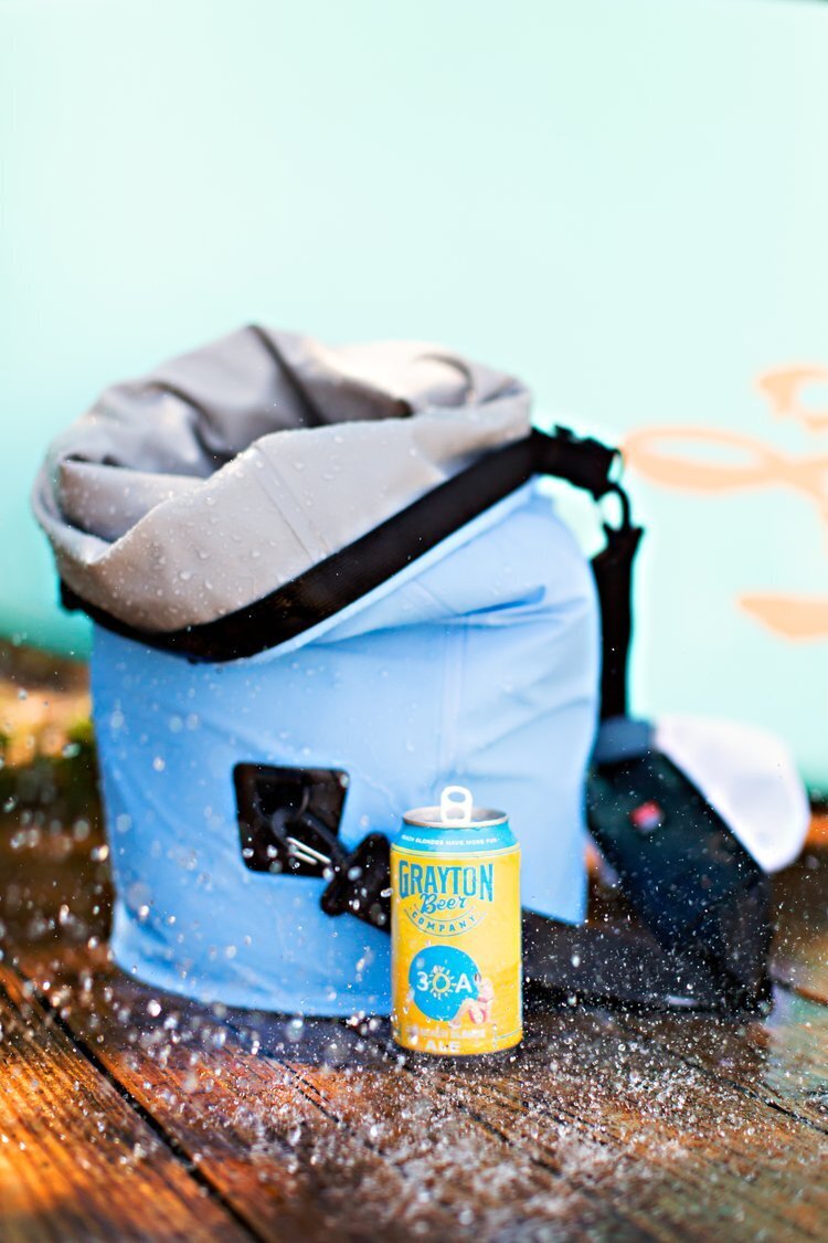Can of beer next to a blue backpack