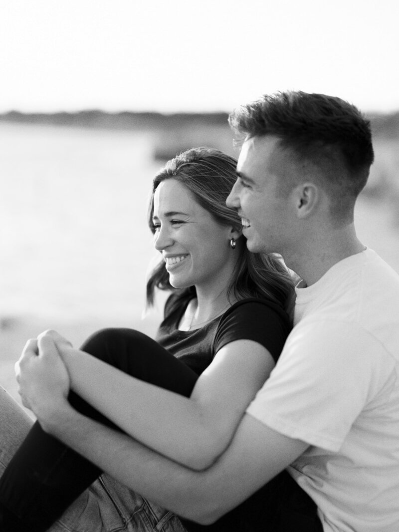 Black and white photo of engaged couple sitting together