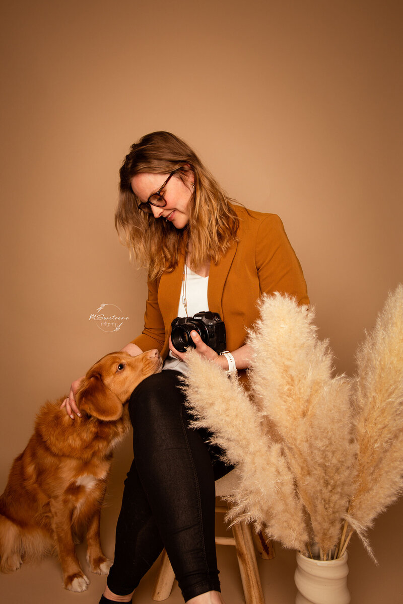 Maura Switsers, hondenfotografe met haar eigen hond. Een toller op de foto in een bohemian setting met droogbloemen in de studio in haar daglichtstudio te Geel 