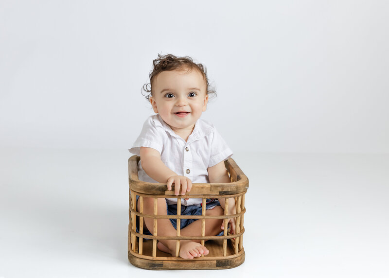 Boy posing for milestone first birthday photo in Allison Reilly's New Jersey photo studio
