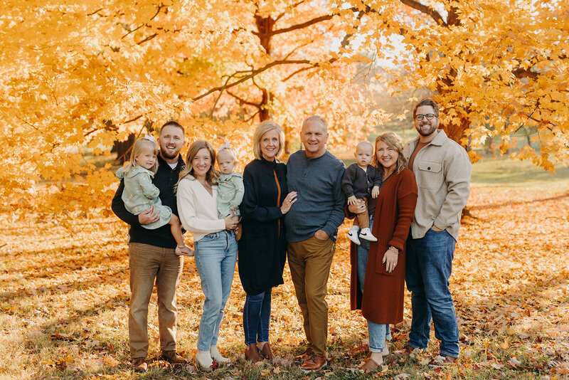 Large family photo in front of fall foliage at Francis Park in St. Louis