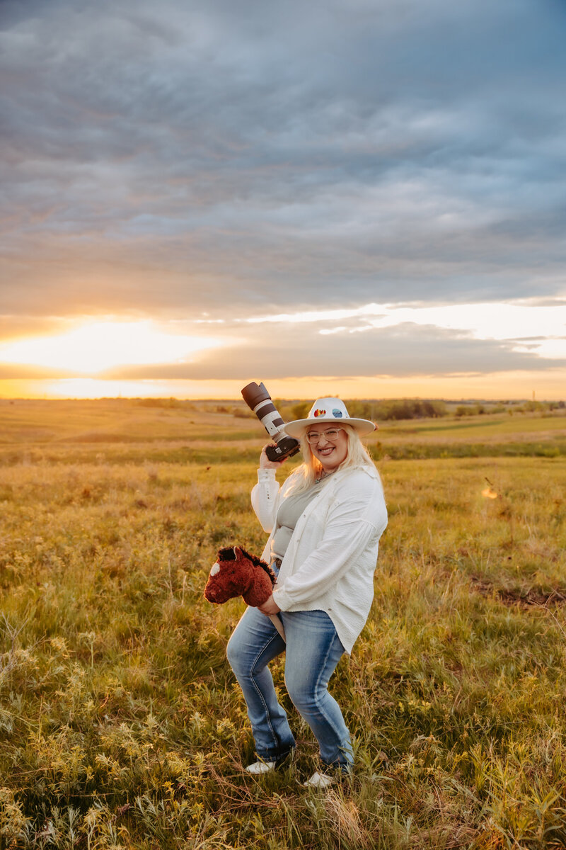 woman holding a camera next to her horse