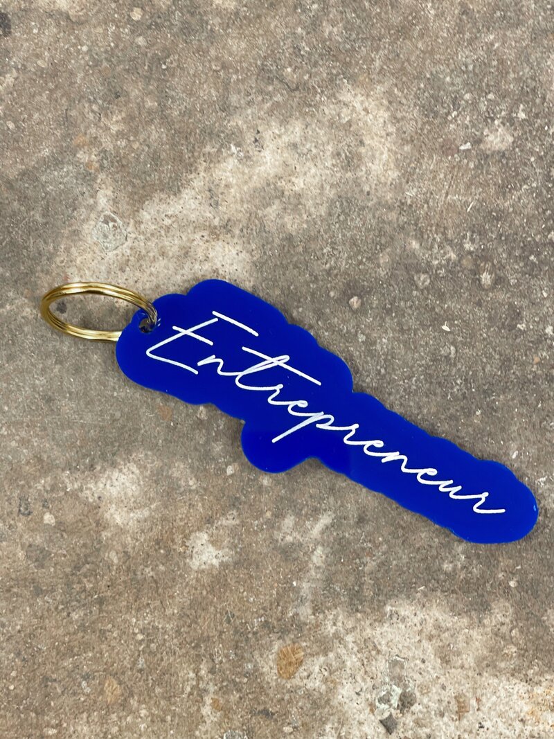 A blue keychain that says entrepreneur