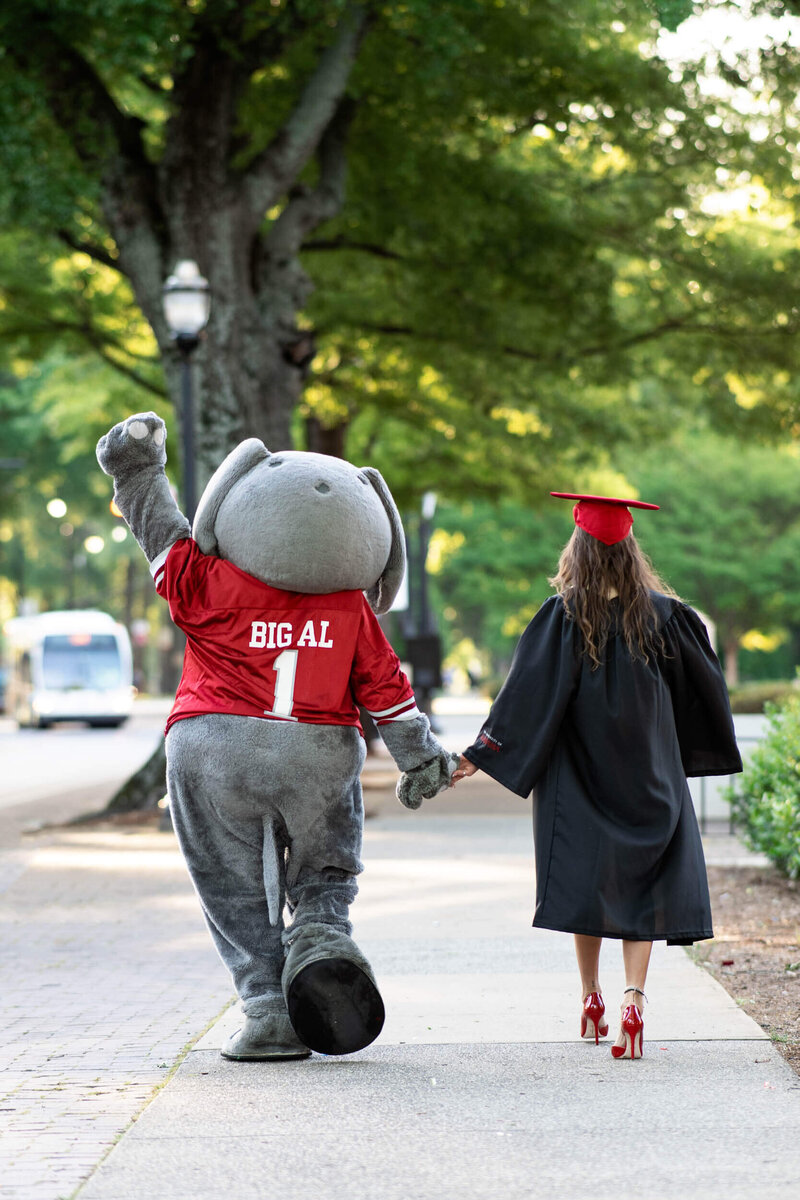 Senior Graduate walking with the school mascot