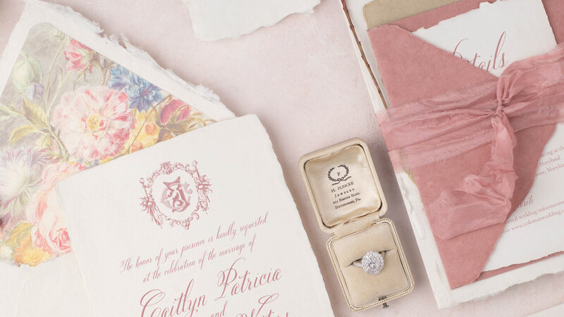 Elegant invitation suite with wedding rings and blush pink detailing