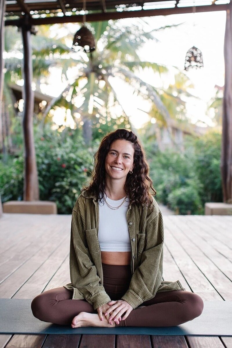Brittany Ugolini, wellness educator and founder of La Línea Studio, seated in a relaxed cross-legged position during a mindful movement practice in San Miguel de Allende.