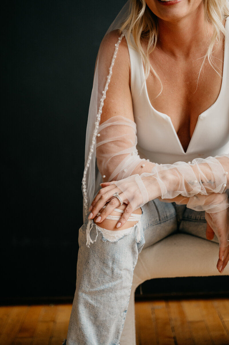 Woman in ripped jeans holding her knees