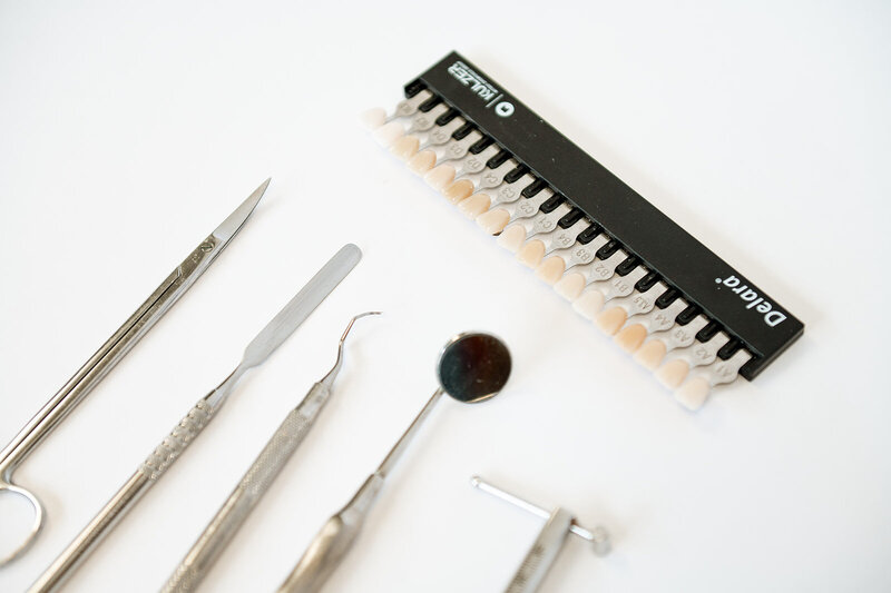 A decorative close up of tools and color swatches used to create custom dentures.