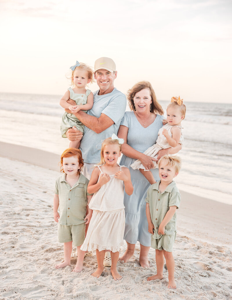 Grandparents laughing with grandchildren at the shoreline