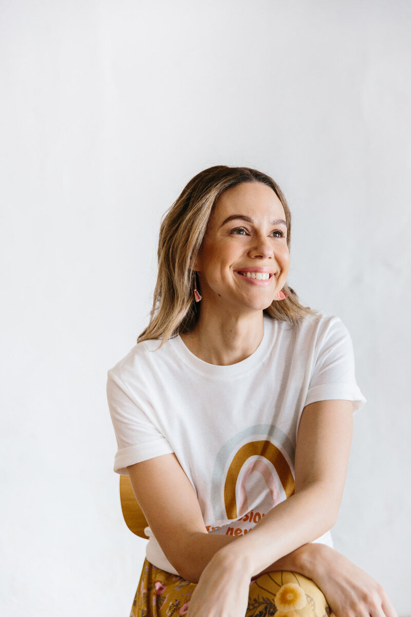 woman with a rainbow t-shirt smiles away from camera