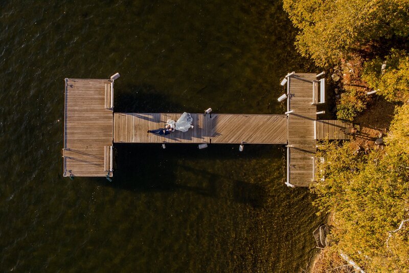 Bride and Groom laying on doc, aerial photo | Rangeley, Maine Wedding Photography