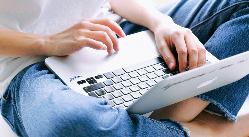 Hands typing on a silver laptop