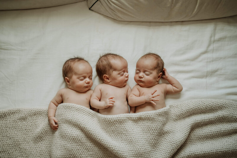 triplets babies sleeping together on their bed in their home in Vancouver